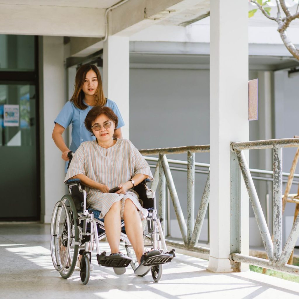 Nurse pushing wheelchair with woman in it