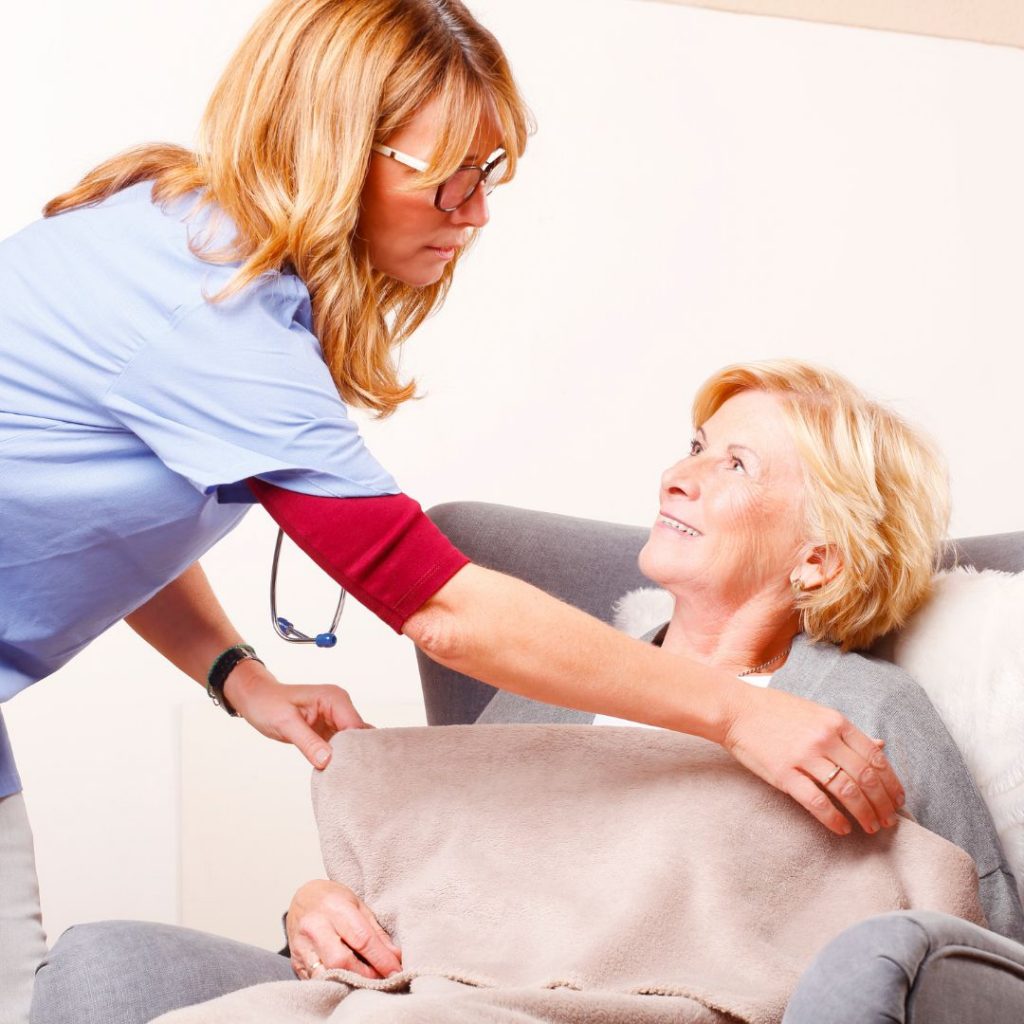 Nurse putting a blanket on a patient