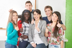 teacher and students showing thumbs up in a classroom